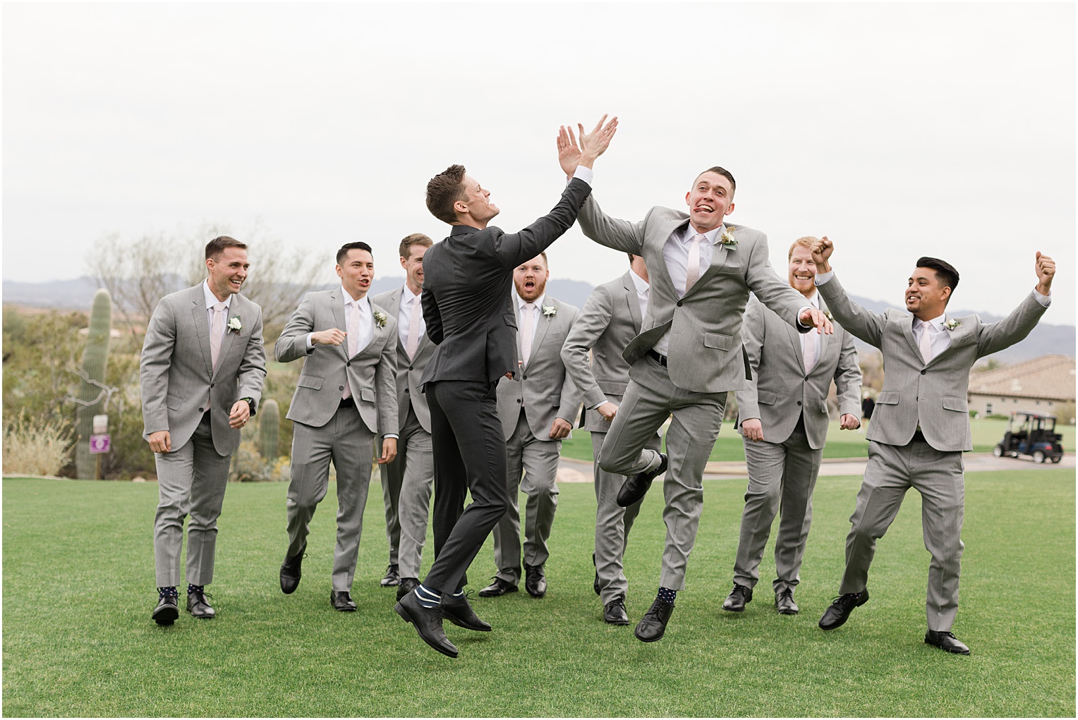 Highlands at Dove Mountain Wedding Grace + Danny fun groomsmen pose in grey and charcoal tuxes