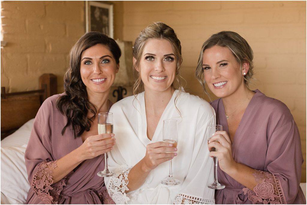 Hacienda Del Sol Wedding Tucson, Arizona bride getting ready with neutral details and matching bridesmaid robes with champagne