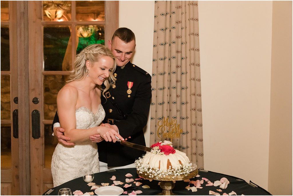 Tanque Verde Ranch Wedding Tucson, AZ Sloan + Garrett wedding reception bride and groom cutting the single layer wedding cake decorated with pink flowers and baby's breath